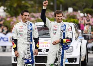 El piloto francés Sebastian Ogier (der) y su copiloto Julien Ingrassia (izq) celebran su cuarto triunfo en el FIA World Rally Championship. AFP PHOTO / ANDREAS SOLARO